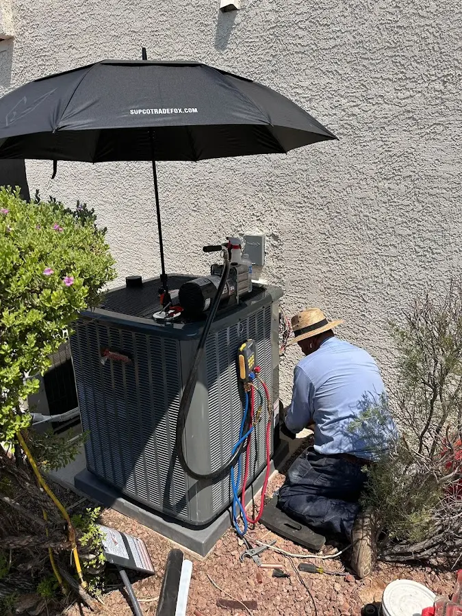HVAC technician performing outdoor AC maintenance in Belvedere Park